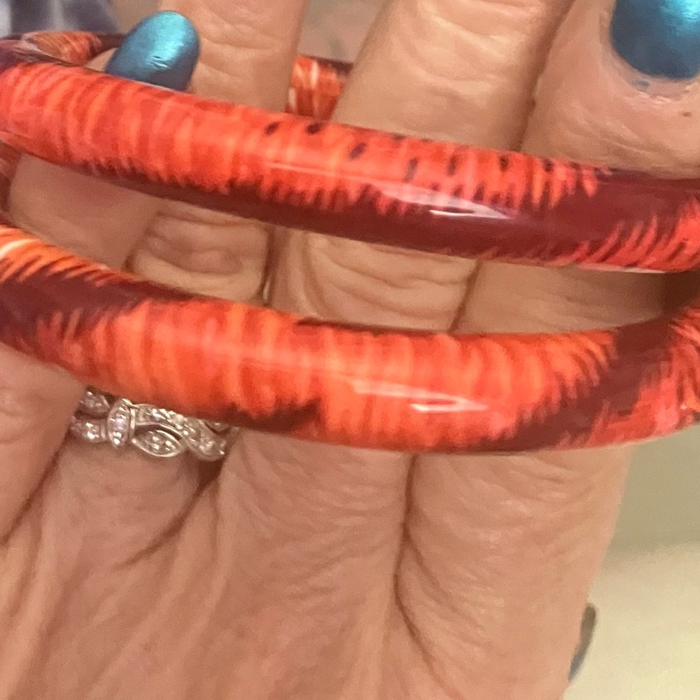 Lot of two vintage, slim bangle, bracelets jungle patterned red